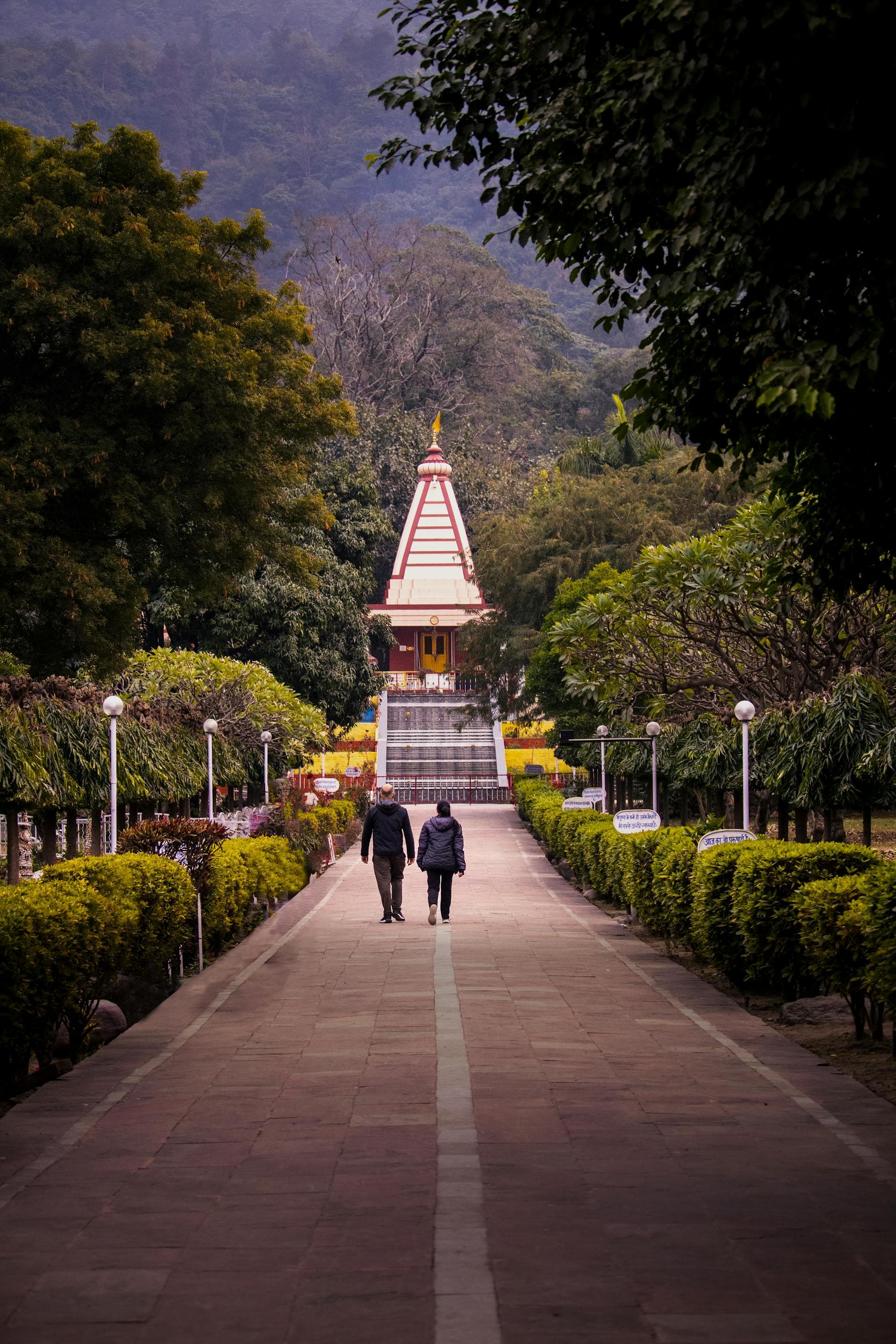 A temple at the end of a tree-lined path in Rishikesh