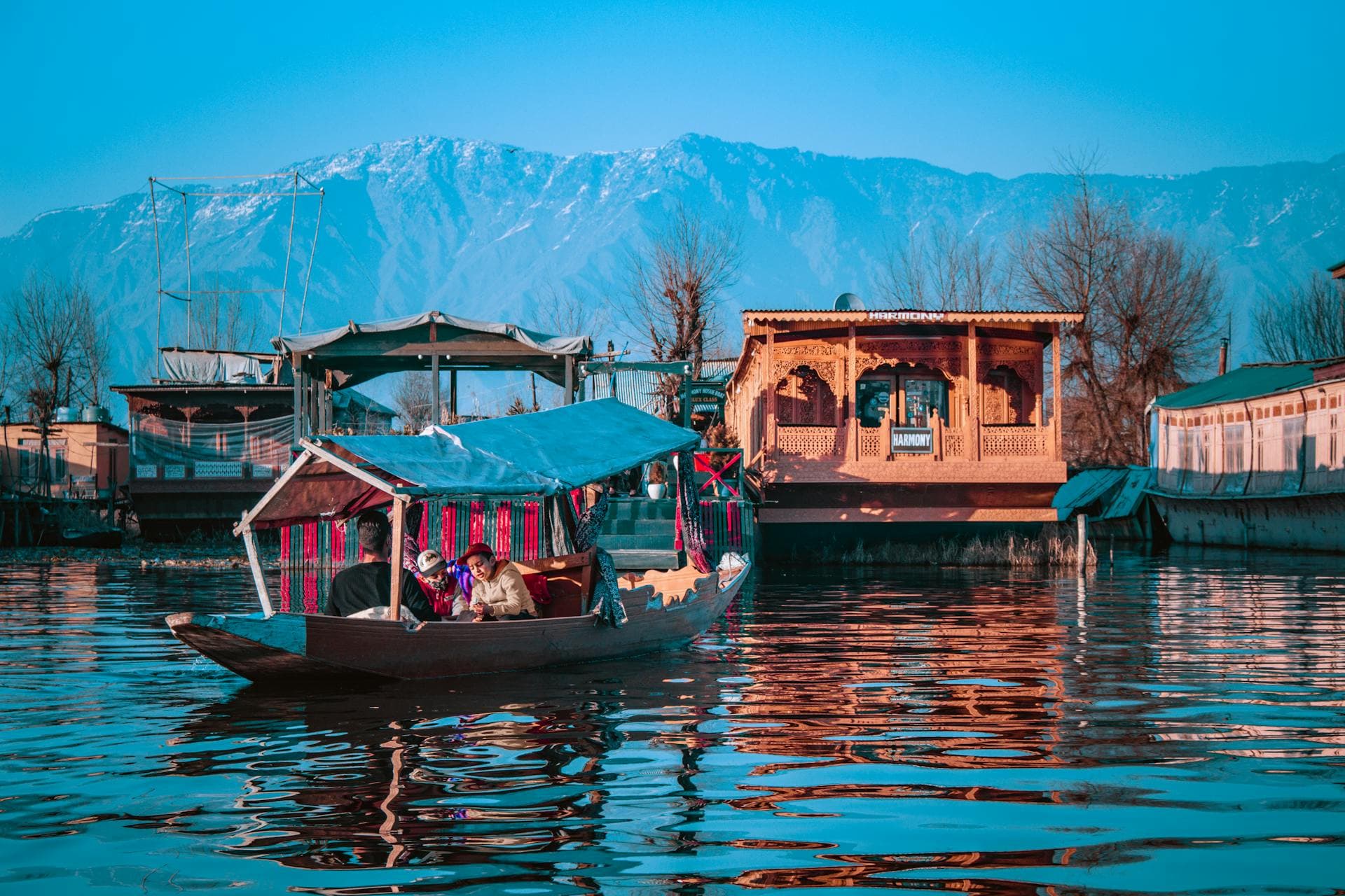 Boats on a lake in Kashmir with mountain peaks in the background